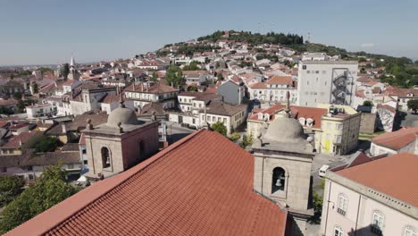 Aerial-backwards-view-of-rooftops-in-scenic-Castelo-Branco,-Portugal