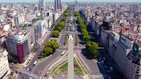 Obelisk-of-Buenos-Aires-City,-9-de-Julio-Avenue,-Aerial-Shot-with-Daylight-Above-the-Downtown-of-the-Argentine-Capital