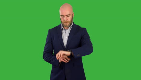 A-businessman-with-a-beard-looking-at-his-watch-impatient-waiting-for-someone-on-green-screen