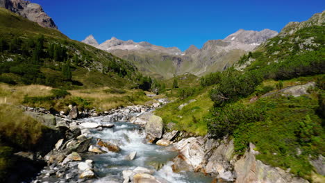 Low-aerial-view-flowing-Zillertal-alps-stream-flowing-through-Tirol-valleys-mountain-range