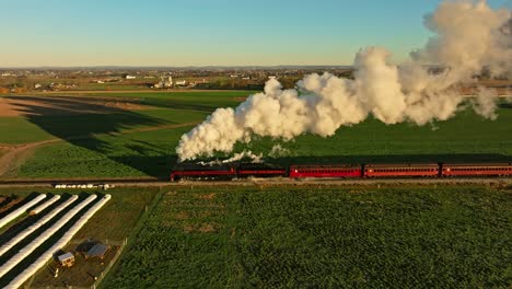 Drone-Parallel-View-of-a-Steam-Engine-Blowing-Lots-of-Smoke-in-the-Early-Morning-Traveling-Thru-the-Farmlands