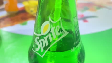 Person-drink-Sprite-soda-with-straw-from-green-bottle,-close-up-POV