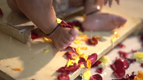 one-1-year-old-baby-bath-with-milk-an-Chandan-haldi-mixture-flowers-royal-bath-by-parents-and-grand-parents-legs