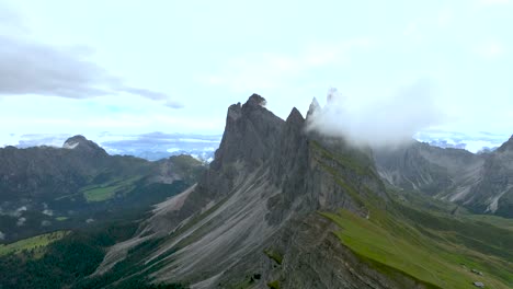 rising-drone-footage-shows-the-craggy-peaks-with-green-mountain-pastures-of-the-dolomite-mountains
