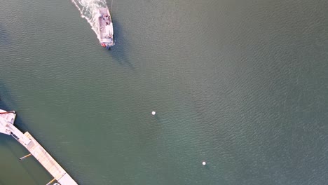 Aerial-top-down-of-salvage-tug,-towing-submerged-sailboat-and-dragging-it-towards-the-shore