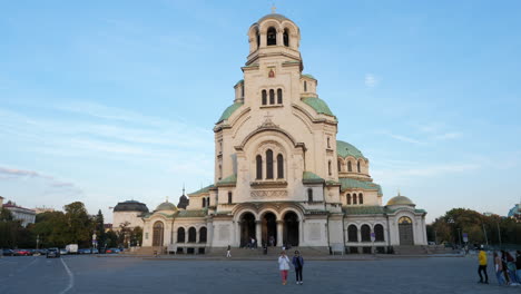 Fachada-Frontal-De-La-Iglesia-Ortodoxa-Alexander-Nevsky-En-Sofia,-Gente-Caminando-En-La-Plaza