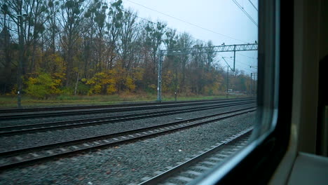 Blick-Auf-Leere-Eisenbahnen-Durch-Glasfenster-Eines-Fahrenden-Zuges-Im-Herbst
