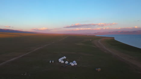 Luftaufnahme-Von-Jurten-Am-Ufer-Des-Malerischen-Song-Kul-Sees-In-Kirgisistan-Bei-Sonnenuntergang