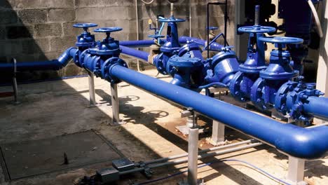 An-establishing-shot-of-a-blue-industrial-irrigation-system,-a-series-of-pressure-valves-and-pumps-engineered-to-control-the-flow-of-water-an-area,-Panama-City