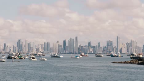 Timelapse-overlooking-the-boats-moored-in-the-Panama-Canal-marina,-in-the-distance-a-scenic-backdrop-of-the-spectacular-modern-buildings-and-beautiful-cityscape-of-Panama-City