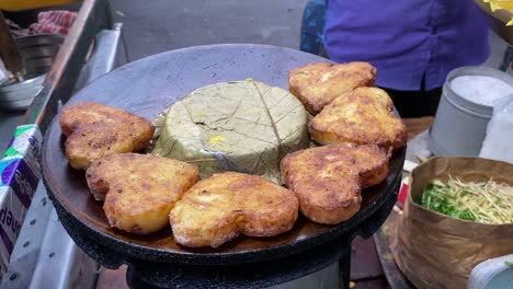 Close-up-shot-over-tasty-heart-shaped-potato-pakora-along-a-roadside-stall-in-Kolkata,-India-at-daytime