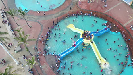 Drohnenaufnahme-Von-Kindern-In-Einem-öffentlichen-Schwimmbad,-Die-Die-Rutschen-In-Durban,-Südafrika,-Benutzen