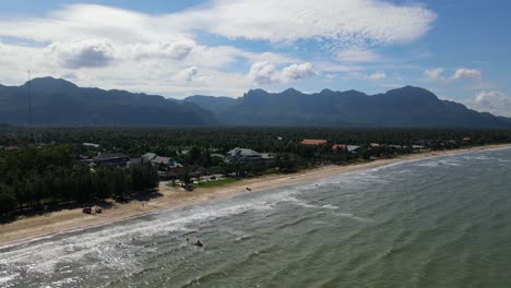 Aufsteigende-Luftaufnahmen,-Die-Einen-Jetski,-Strand,-Kokospalmen,-Berge-Und-Himmel-Zeigen