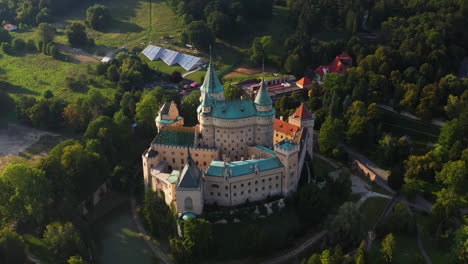 Cinematic-revealing-drone-shot-of-Bojnice-Castle,-Castle-Of-Spirits,-in-Slovakia