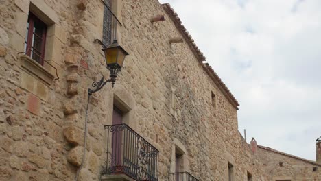 Medieval-Cobblestone-Architecture-With-Balcony-And-Old-Street-Lamp