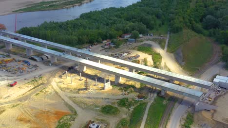 Toma-Aérea-Que-Pasa-Sobre-Un-Proyecto-De-Construcción-De-Puente-Al-Atardecer-En-Vistula-Cerca-De-Varsovia