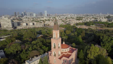 Versteckte-Schöne-Rosa-Kirche,-Umgeben-Von-Bäumen-In-Tel-Aviv,-Israel