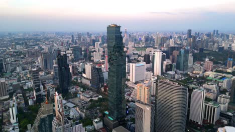 Drone-Shot-of-Mahanakhon-Tower-skywalk,-rooftop,-in-Bangkok,-Silom-area,-business-district,-downtown