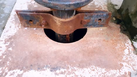 Close-up-view-of-ground-water-extraction-from-well-through-metal-pipe-connected-to-suction-motor