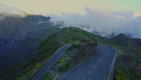 Aerial-moving-over-hairpin-turn-on-road-above-beautiful-cloud-filled-valley