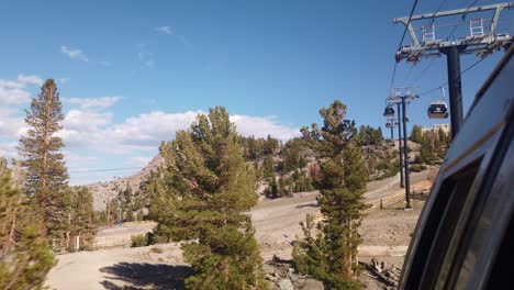 Gimbal-static-shot-from-gondola-looking-backward-up-the-mountain-as-it-passes-over-the-tree-line-on-Mammoth-Mountain-in-California-during-the-summer