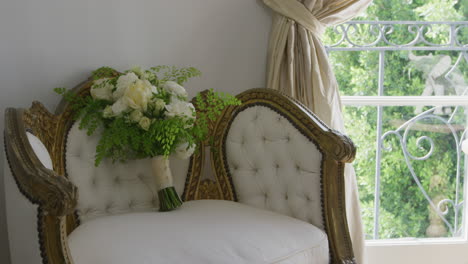 Hochzeitsstrauß-Mit-Weißen-Und-Grünen-Blumen-Auf-Einem-Antiken-Stuhl-Mit-Ornamenten
