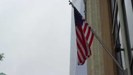 American-Flag-Waving-On-Building-Exterior-In-New-York-City,-USA