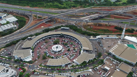 Drone-shot-over-La-Lucia-Mall,-Durban-South-Africa-with-busy-highway-interchange-in-background