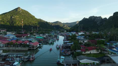 Reverse-aerial-footage-of-this-lovely-fishing-village-and-a-river-with-fishing-boats-moored-to-the-sides