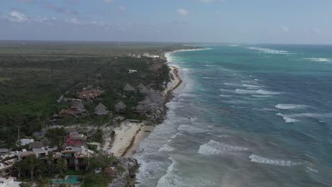 Aerial-high-angle-shot-of-idyllic-coastline-of-Tulum-in-Mexico---Turquoise-colored-water,-sandy-beach-and-green-scenery-in-background
