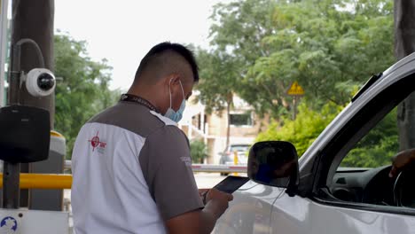 Mexican-Latin-American-Private-Security-Guard-Verifying-ID-Of-Person-With-A-Tablet-And-Security-Camera-As-He-Drives-His-Van-Into-A-Private-Resort