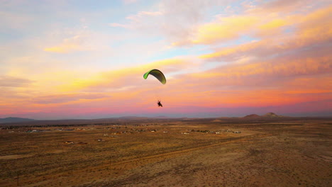 Volando-Junto-A-Un-Piloto-De-Parapente-Motorizado-Durante-Una-Colorida-Puesta-De-Sol-Sobre-El-Desierto-De-Mojave