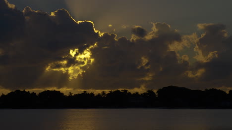Sun-Rays-Stream-Out-From-Behind-Clouds-Over-Inlet-In-South-Florida,-U