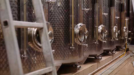 Trucking-shot-along-stainless-steel-tanks-in-cellar-used-for-wine-fermentation
