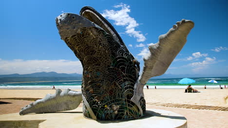 Steel-sculpture-of-breaching-humpback-whale-installed-at-Central-Beach,-Plett