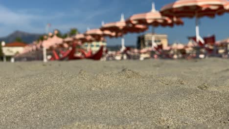 Sandstrand-Auf-Einem-Verschwommenen-Hintergrund-Von-Strandsonnenschirmen-In-Der-Frischen-Brise