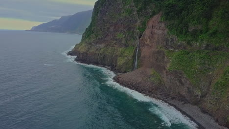 Aerial-view-as-Véu-da-Noiva-waterfall-flows-into-the-ocean-from-cliff,-Madeira