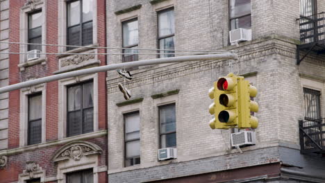 Sneakers-On-Traffic-Signal-With-New-York-City-Apartment-Buildings-In-Background
