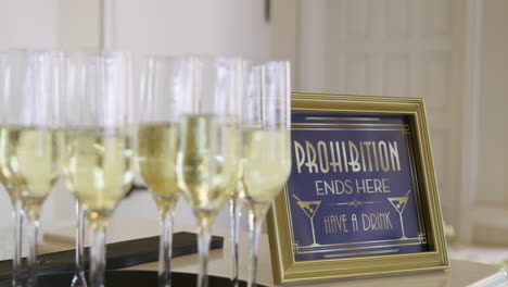 Sparkling-Wedding-Champagne-Glasses-in-Front-of-Sign-that-says-Have-a-Drink