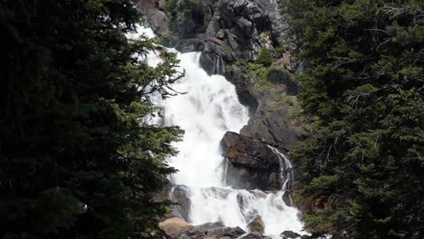 Beautiful-nature-close-up-tilting-up-shot-of-the-Hidden-Falls-waterfall-up-on-a-hike-in-the-Grand-Teton-National-Park-in-Wyoming,-USA