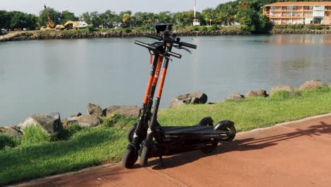 Couple-of-electric-scooters-entangled-over-each-other-outdoors-under-the-morning-sun-for-rent-that-are-owned-by-a-innovative-tech-company-in-Panama-City's-Causeway-of-Amador