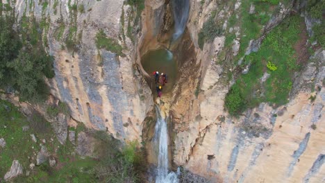 Climbers-next-to-precipice-and-waterfall-ready-for-rappelling