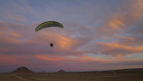 Silhouette-of-a-powered-paraglider-over-the-Mojave-Desert-landscape-during-an-epic-sunset
