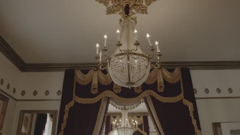 Antique-gold-chandeliers-with-lit-up-candles-at-a-mansion-wedding-venue