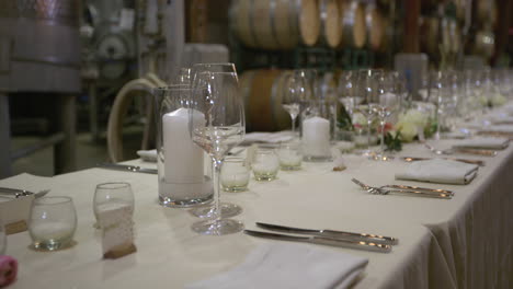 Empty-large-rectangle-white-wedding-table-full-of-crockery-and-cutlery