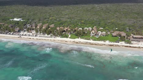 Kitesurfen-über-Dem-Meer-Am-Strand-Von-Tulum-Mit-Wald-Im-Hintergrund,-Mexiko