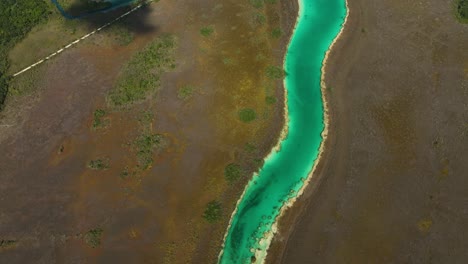 Aerial-overview-of-the-colorful-Bacalar-rapids,-in-sunny-Mexico---tilt,-drone-shot