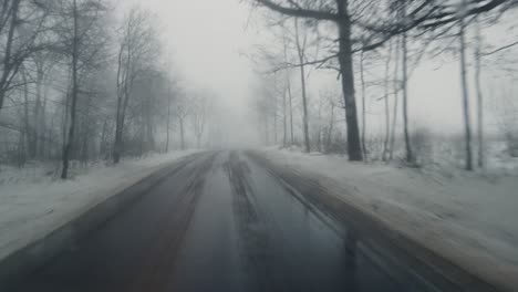 Pov-Aus-Einem-Fahrenden-Auto-Auf-Einer-Verschneiten,-In-Nebel-Gehüllten-Straße