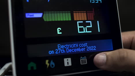 Close-Up-Of-Finger-Pressing-Touchscreen-Display-Of-UK-Energy-Smart-Meter-To-Check-Daily-Cost-Of-Electricity-During-A-Week-In-December-2022