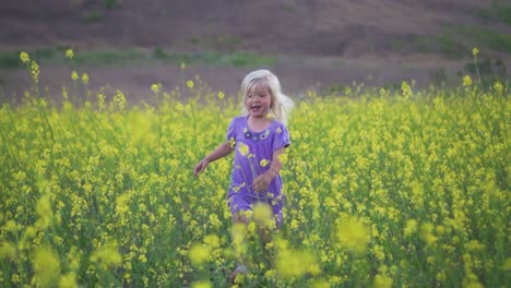 Glückliches-Junges-Mädchen-Läuft-In-Zeitlupe-Durch-Ein-Feld-Gelber-Blumen-Auf-Die-Kamera-Zu